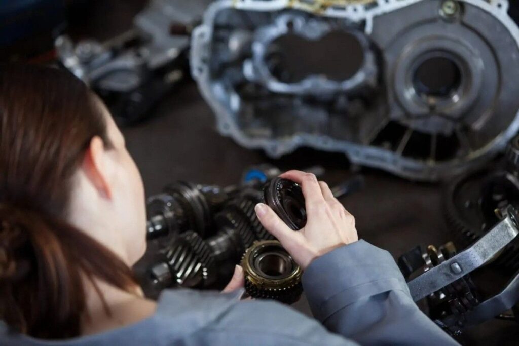 Mechanic inspecting automotive components during timing belt service